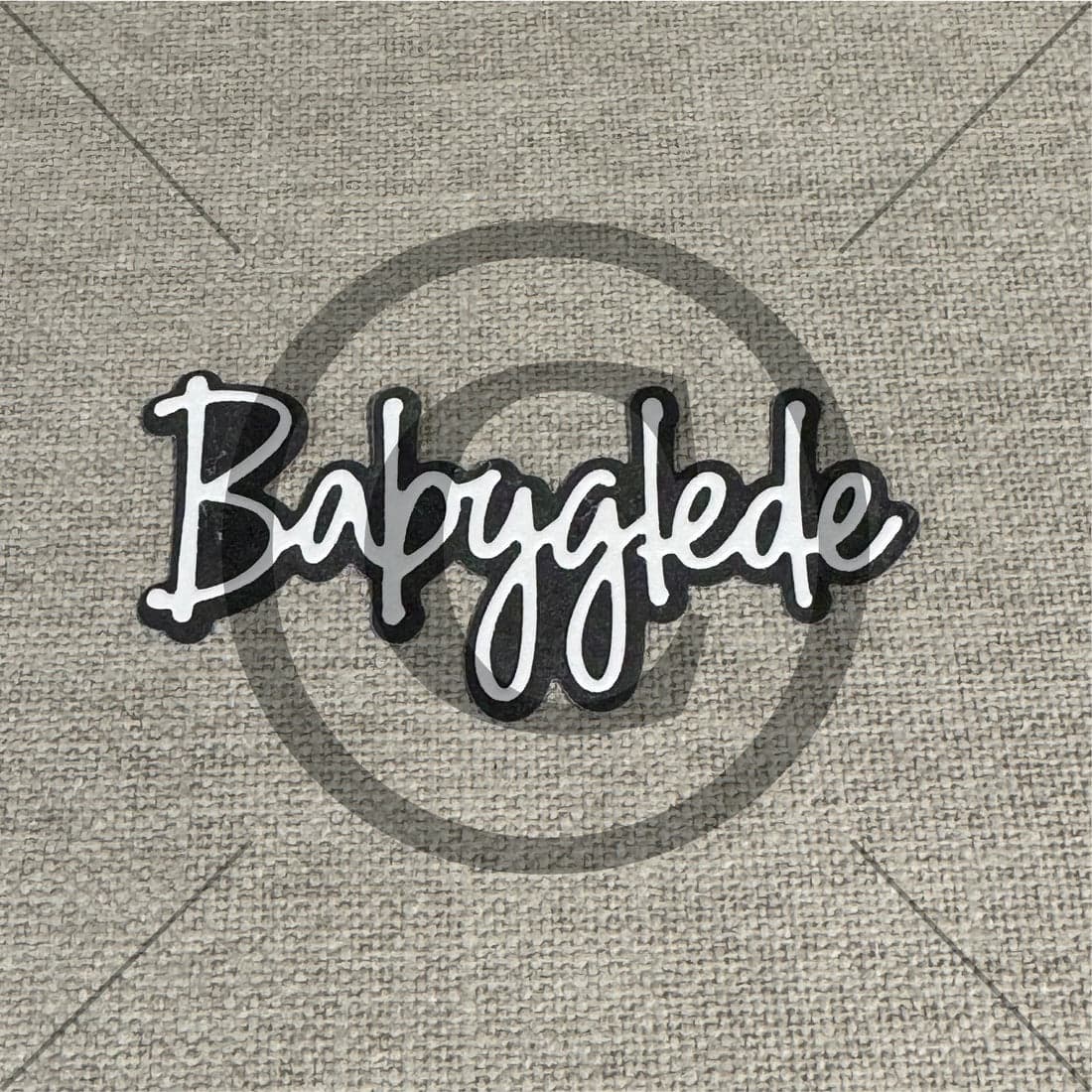 Babyglede merkelogo på tekstilbakgrunn