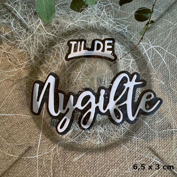 Hvit og sort brodert tekstlappi med teksten 'TILDE' og 'Nygitt'